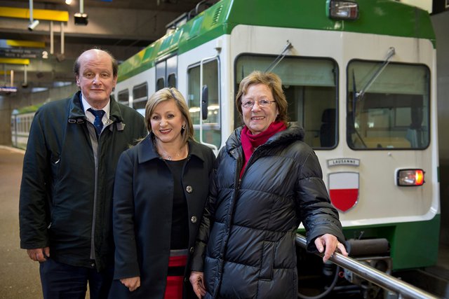 Les trois personnages posent à la station Flon devant une rame du LEB.