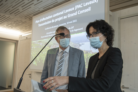 Les deux personnages devant un écran lors de la conférence de presse.