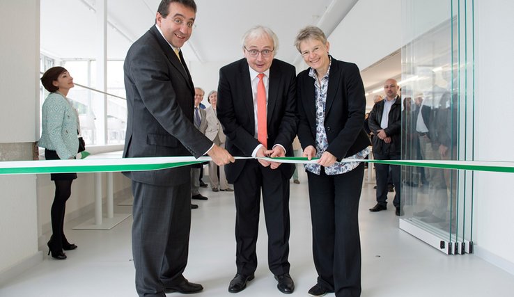 Les trois personnages posent. C'est Monsieur Vanhulst, recteur, qui coupe le ruban.
