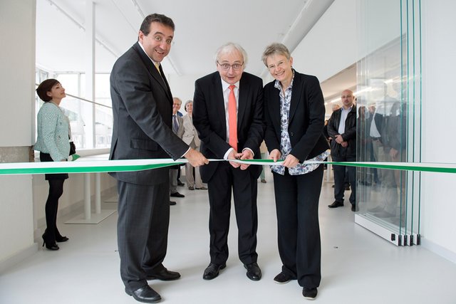 Les trois personnages posent. C'est Monsieur Vanhulst, recteur, qui coupe le ruban.