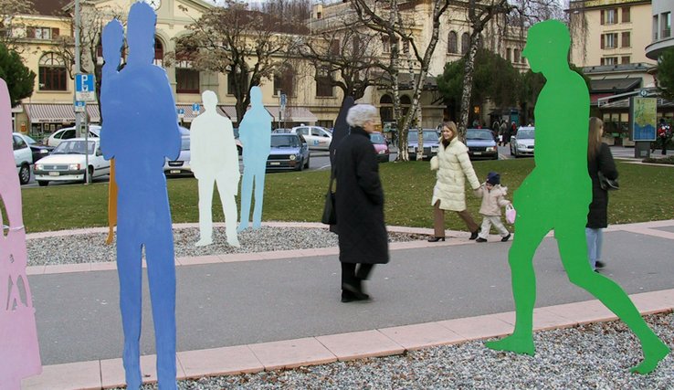 Passants et sculptures en forme de silhouettes devant la gare de Vevey.