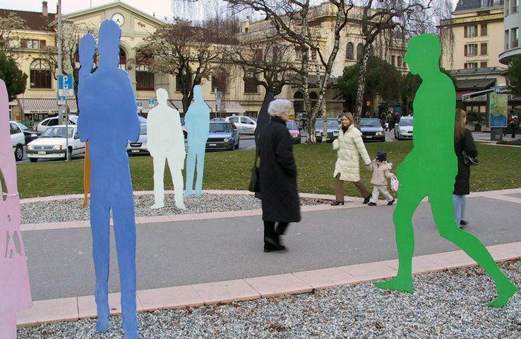 Passants et sculptures en forme de silhouettes devant la gare de Vevey.