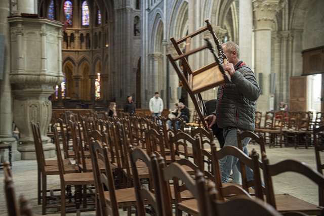 Un acheteur soulève une chaise dans la cathédrale.