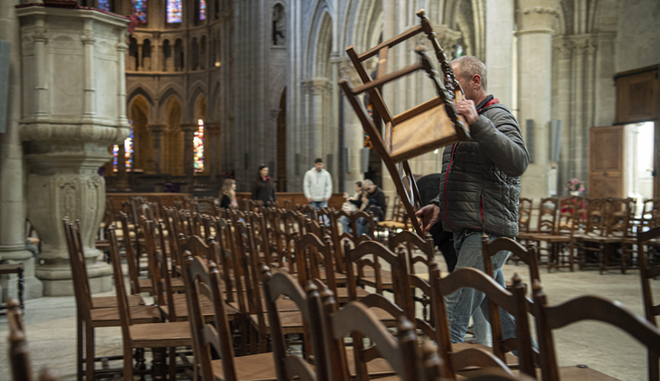 Un acheteur soulève une chaise dans la cathédrale.