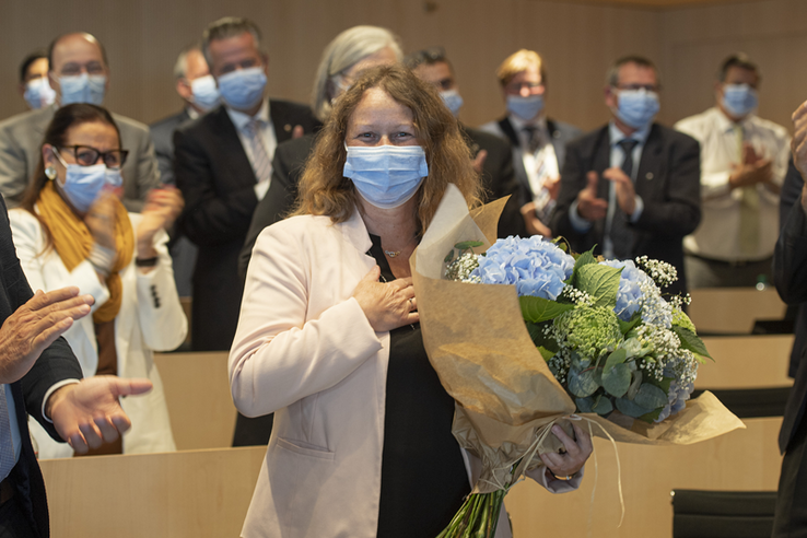 La nouvelle présidente pose masquée, avec un bouquet d'hortensias et la main sur le coeur