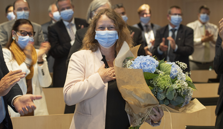 La nouvelle présidente pose masquée, avec un bouquet d'hortensias et la main sur le coeur