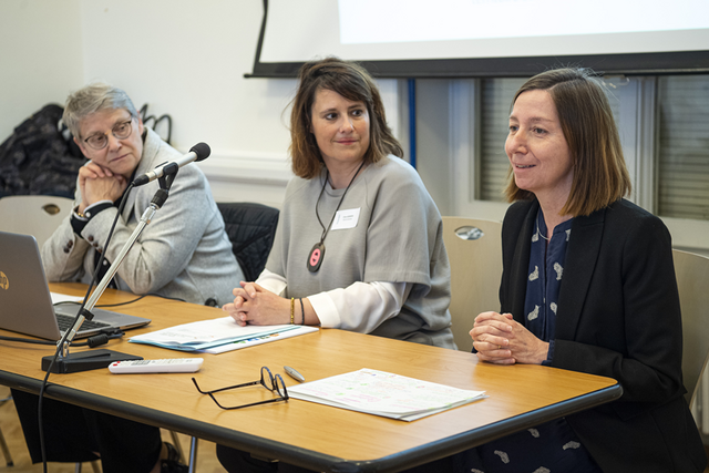 Les trois personnes sont assises à une table, en conférence de presse.