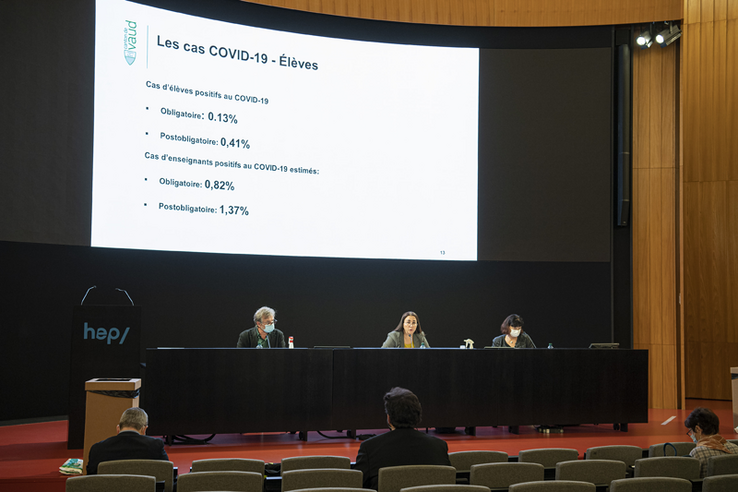 La conseillère d'Etat Cesla Amarelle et deux collaborateurs pendant la conférence de presse, sur la scène de la HEP-VD.