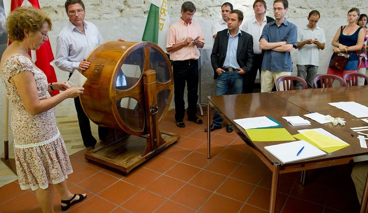 Eric Golaz, chef du Service des communes et des relations institutionnelles, procède au tirage au sort à l'aide de la machine rotative qui brasse les listes.