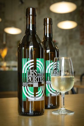 deux bouteilles avec un verre remplli. L'étiquette forme un ensemble géométrique.