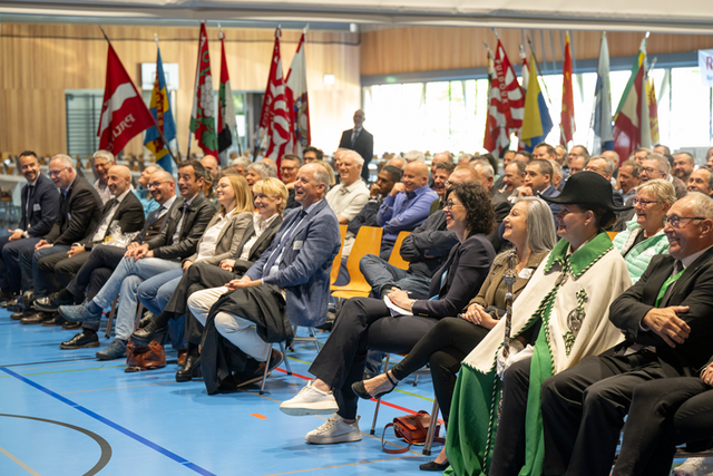 plusieurs membres du Conseil d'Etat ainsi que des invités assis, assitent à un discours et rient.