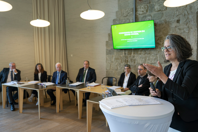 Madame Sarrasin en train de présenter le rapport. Au fond, ses collègues de la Commission.