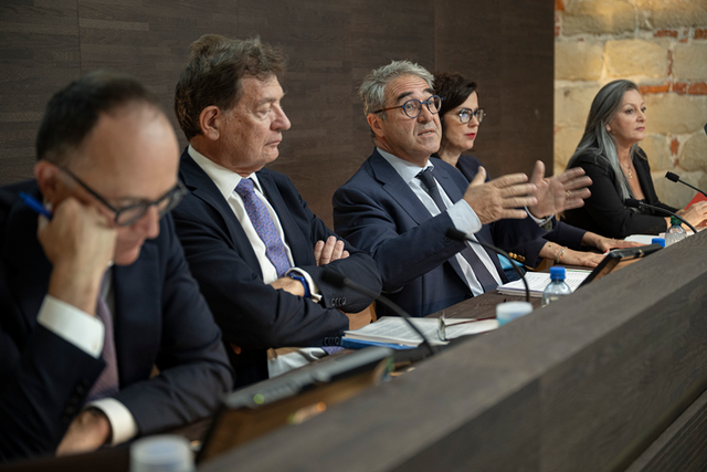 Les personnes sont installées derrière leur pupitre, lors de la conférence de presse. Monsieur Borloz parle en levant les mains.