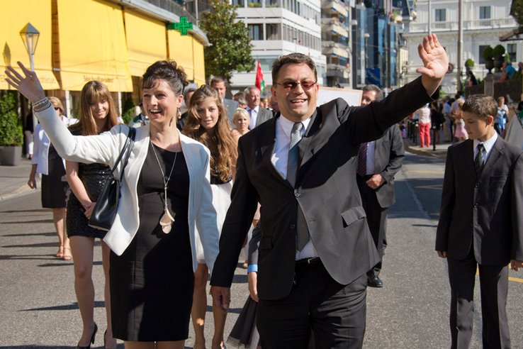 Madame et Monsieur Wehrli, mains levées, souriants. Au second plans, des adolescents.