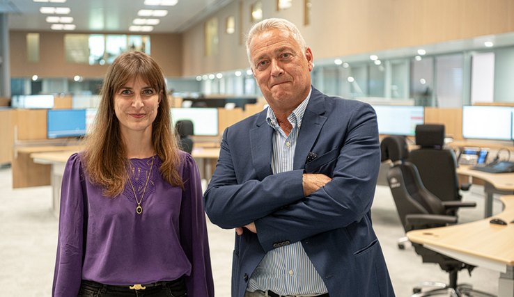 Les deux personnages posent dans la salle de réception des appels de la centrale d'alarme.