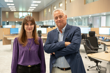 Les deux personnages posent dans la salle de réception des appels de la centrale d'alarme.