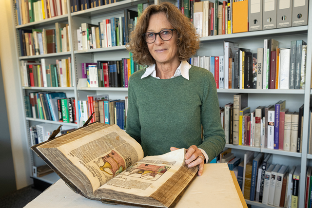 Joëlle Magnin-Gonze, conservatrice de la bibliothèque et des jardins du Naturéum, tourne les pages d’un recueil vieux de 500 ans. Il rassemble quatre ouvrages qui indiquent quelles plantes servent à se soigner, comment les utiliser et en extraire les substances actives ou comment cultiver son jardin. Photo | ARC-Sieber