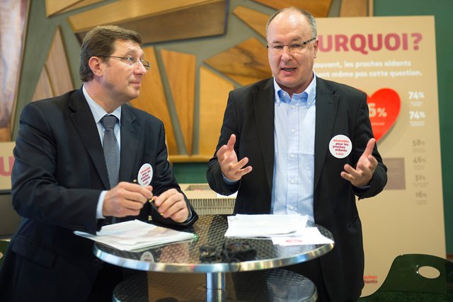 Les deux hommes sur scène, portant des badges de la journée.