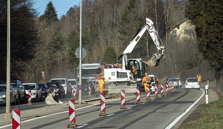 Image représentant une route en travaux avec un trax et des ouvriers de la route