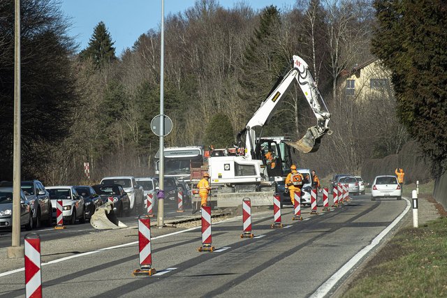 Image représentant une route en travaux avec un trax et des ouvriers de la route