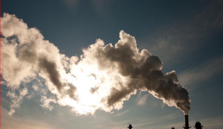 cheminée d'usine avec fumée sur fond de ciel bleu