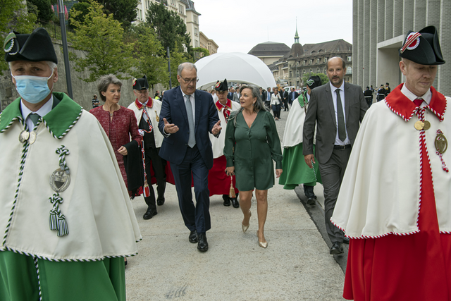 Les personnages marchent devant le Musée cantonal des Beaux-Arts, deux huissiers en tête.