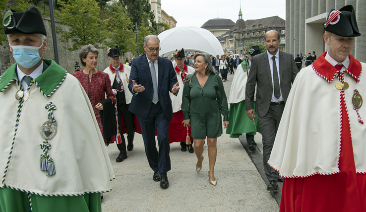 Les personnages marchent devant le Musée cantonal des Beaux-Arts, deux huissiers en tête.