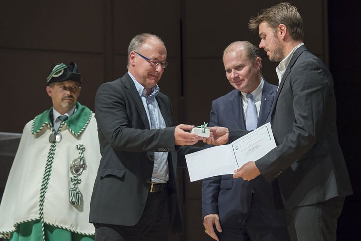 Pierre-Yves Maillard tend un coffret à Stan Wawrinka, devant Philippe Leuba. Stan Wawrinka a déjà un diplôme dans la main.