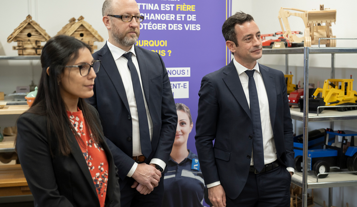 Les personnes posent. Derrière elles, des rayonnages avec des produits manufcaturés en bois par les personnes en détention (maisons pour oiseaux, jouets d'enfants...)