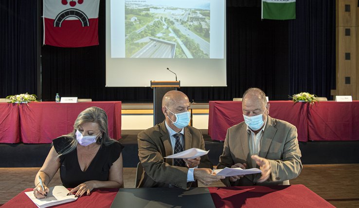 Les personnages assis derrière une table en train de signer la convention.