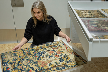 Magali Junet, conservatrice de la collection Toms Pauli, extrait cette pièce chamarrée, brodée au petit point par une main anonyme dans l’Angleterre de 1710. Photo | ARC-Sieber