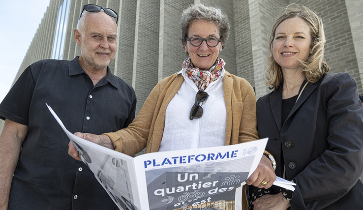 Les trois personnages posent devant le M C B A, tenant un magazine marqué Plateforme 10.