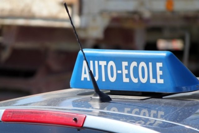Signal "auto-école" monté sur le toit d'une voiture.