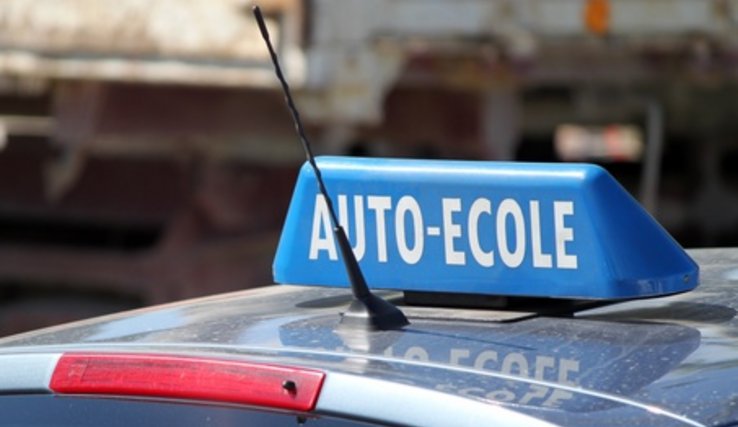 Signal "auto-école" monté sur le toit d'une voiture.