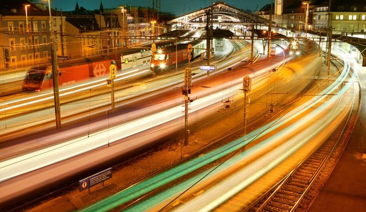 La marquise de la gare de nuit avec des trains en mouvement.