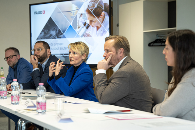 les personnages assis côte à côte à une table durant la conférence de presse