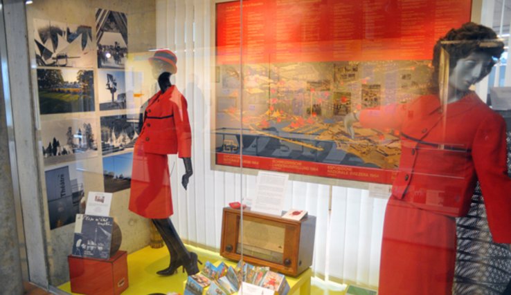 Vitrine de l'exposition des Archives cantonales: on voit notamment deux mannequins vêtus des costumes des hôtesses de l'Expo 64.