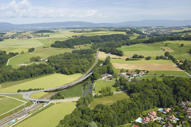 Vue du ciel: un viaduc enjambe la Venoge et la voie ferrée. On voit un bras secondaire élargi de la rivière (une des mesures de renaturation.)