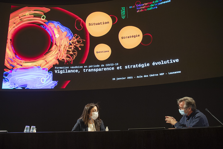 Cesla Amarelle et Eric Masserey devant un écran géant, en conférence de presse.