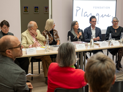 les personnes côte à côte derrière une table. Sur un écran derrière, s'affiche le logo de la Fondation Planque