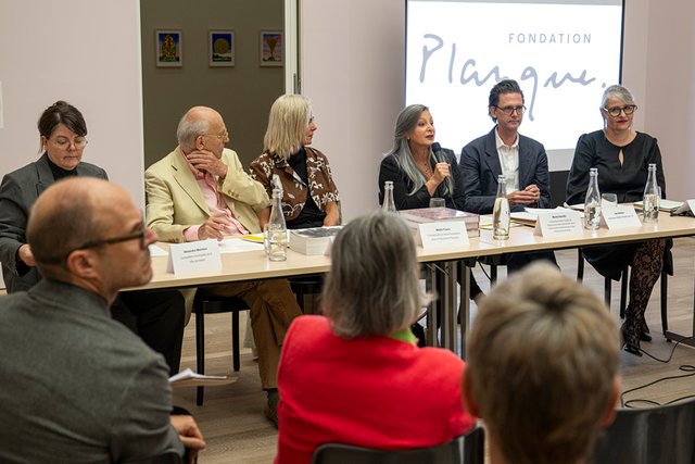 les personnes côte à côte derrière une table. Sur un écran derrière, s'affiche le logo de la Fondation Planque