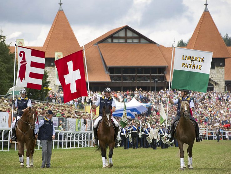 cavaliers porteurs des drapeaux du Jura, de la Suisse et du canton de Vaud, à la parade de dimanche au Marché-Concours de Saignelégier - Photo ARC-Sieber