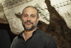 portrait dans une cave ou une grotte. il porte une barbe.