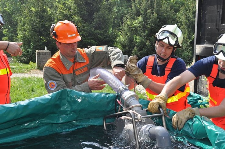 intervenants de la Protection civile manoeuvrant une pompe de défense incendie