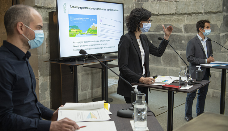 La conseillère d'Etat entourée de deux collaborateurs, en conférence de presse.