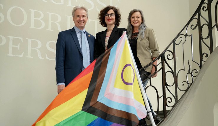 C Luisier N Gorrite et L Mievielle posent devant le drapeau LGBTQ