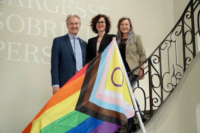 C Luisier N Gorrite et L Mievielle posent devant le drapeau LGBTQ