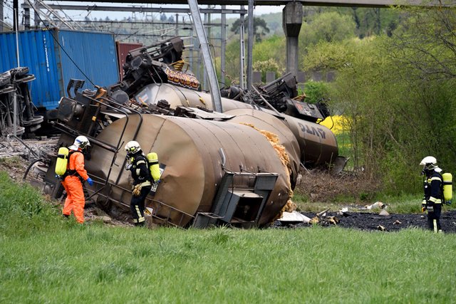 wagons citernes renversés avec pompiers revêtus de combinaisons protectrices