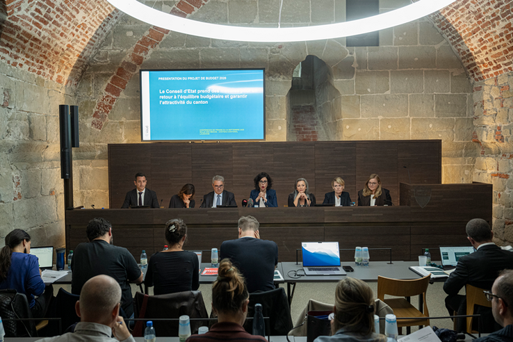 le conseil d'état in corpore lors de la conférence de presse, mercredi 24 septembre 2025 au château cantonal. Les membres du consiel d'état sont assis derrière le grand bureau face aux médias.