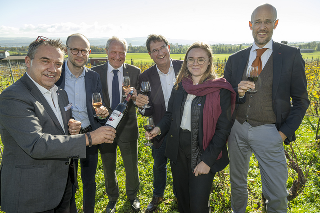 Les personnages dans une vigne, en train de déguster des verres de vin.